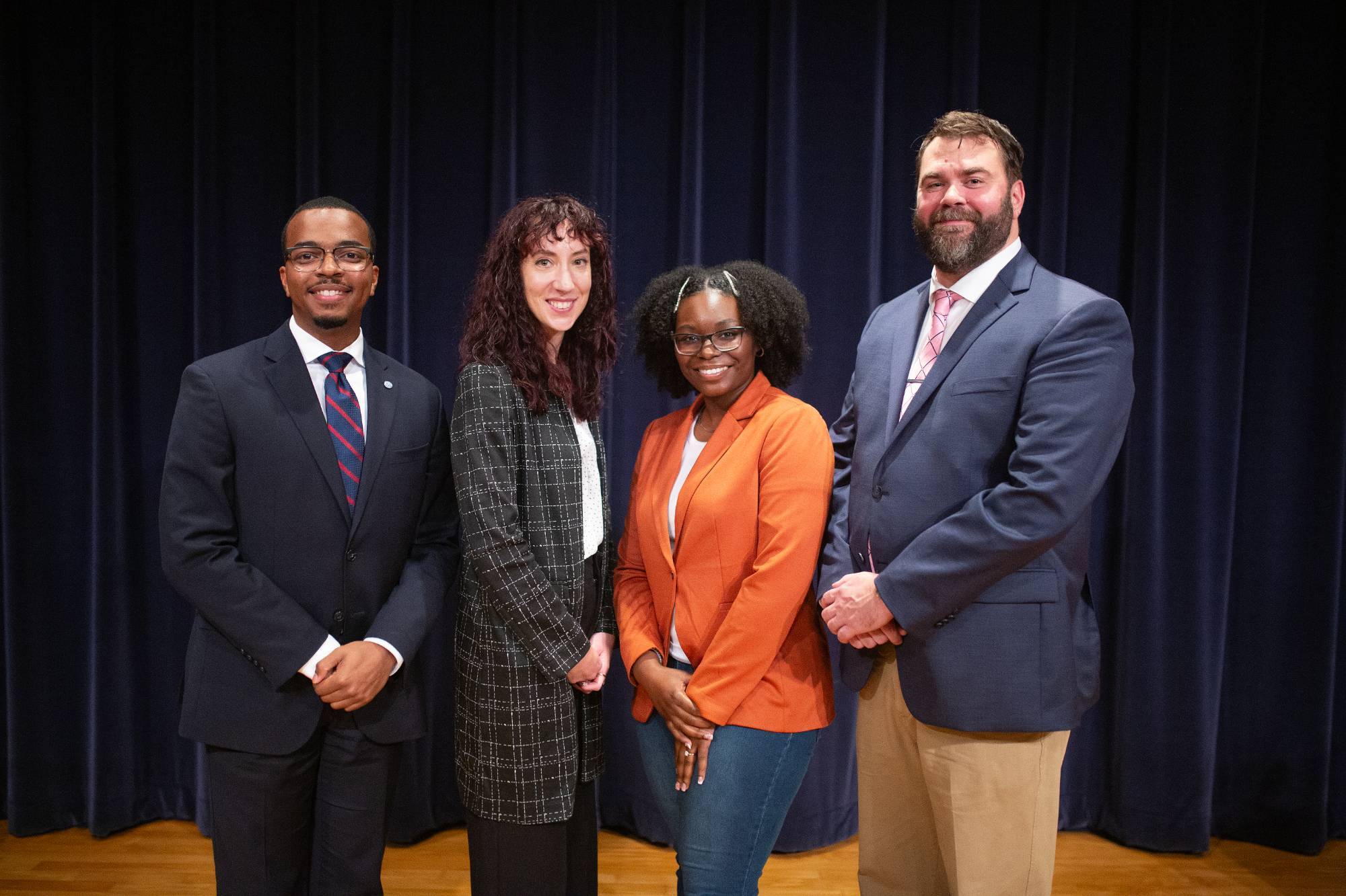 Alumni of the Peter C. Cook Leadership Academy pose for a photo on stage followng an Alumni Panel event.